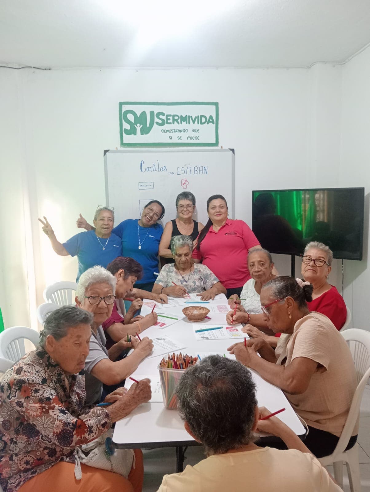 Personas mayores del programa Canitas trabajando alrededor de la mesa durante una sesión de la sede.